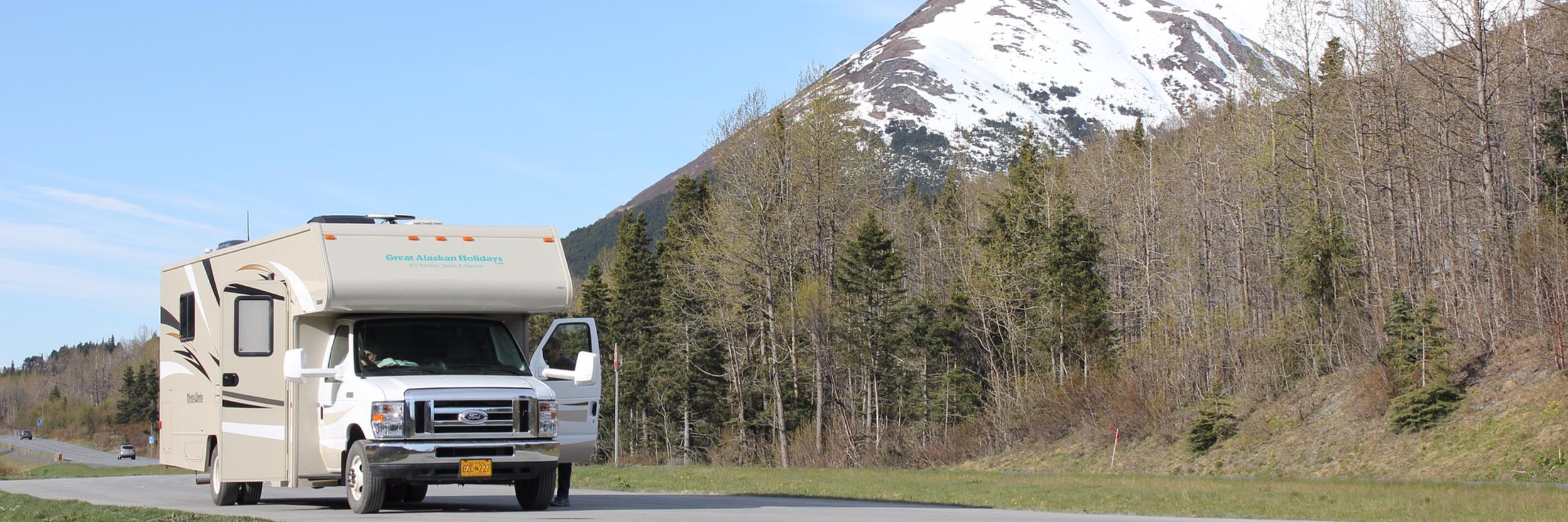 RV camper parked beside mountain